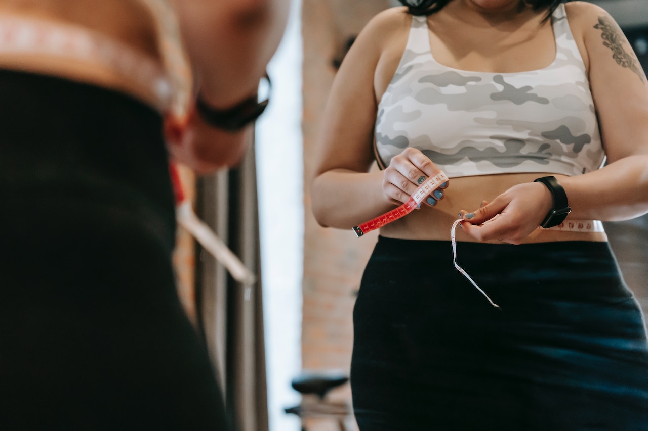 Concerned lady measuring waist line